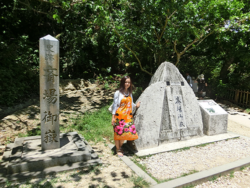 石碑の横で記念撮影する観光客