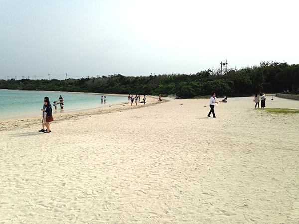 砂浜で運動する観光客